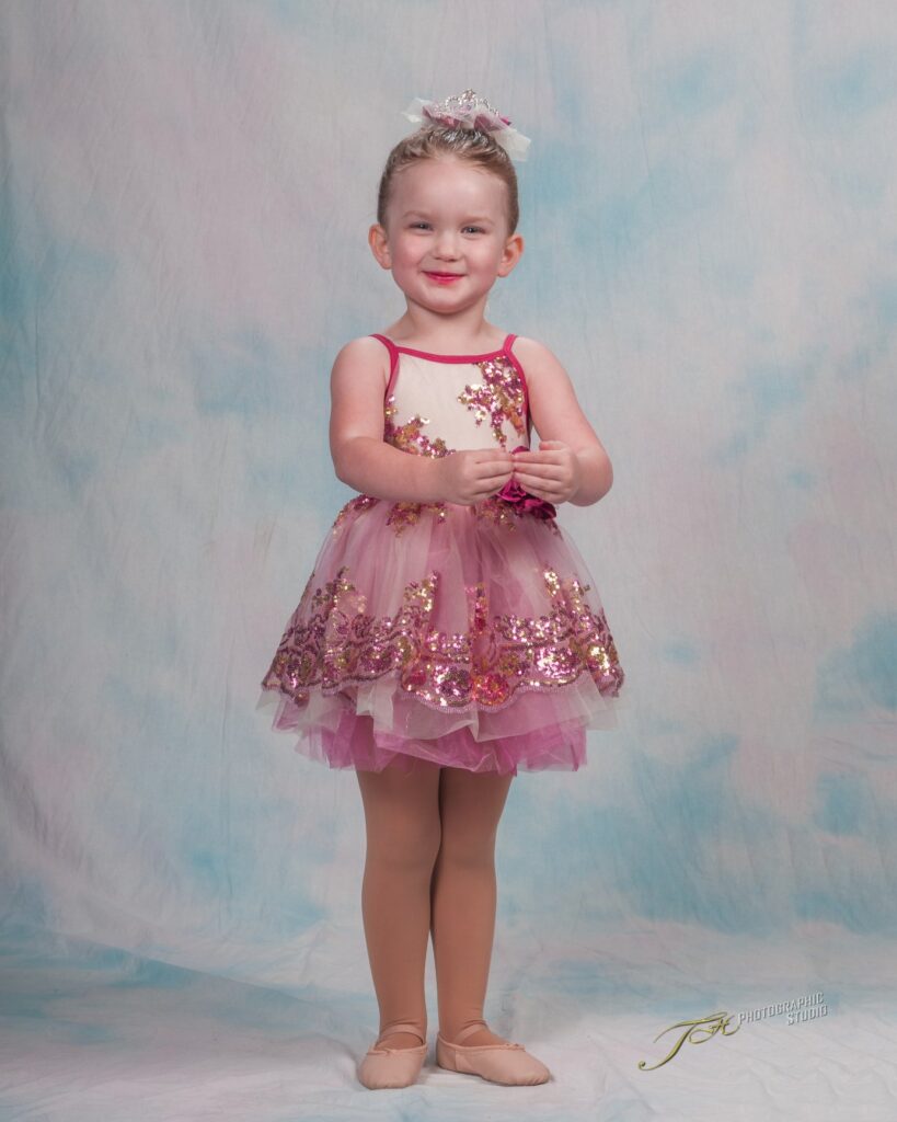 Adorable Little Dancer Dressed In Pink Photographed on a Soft Pink and Blue Background