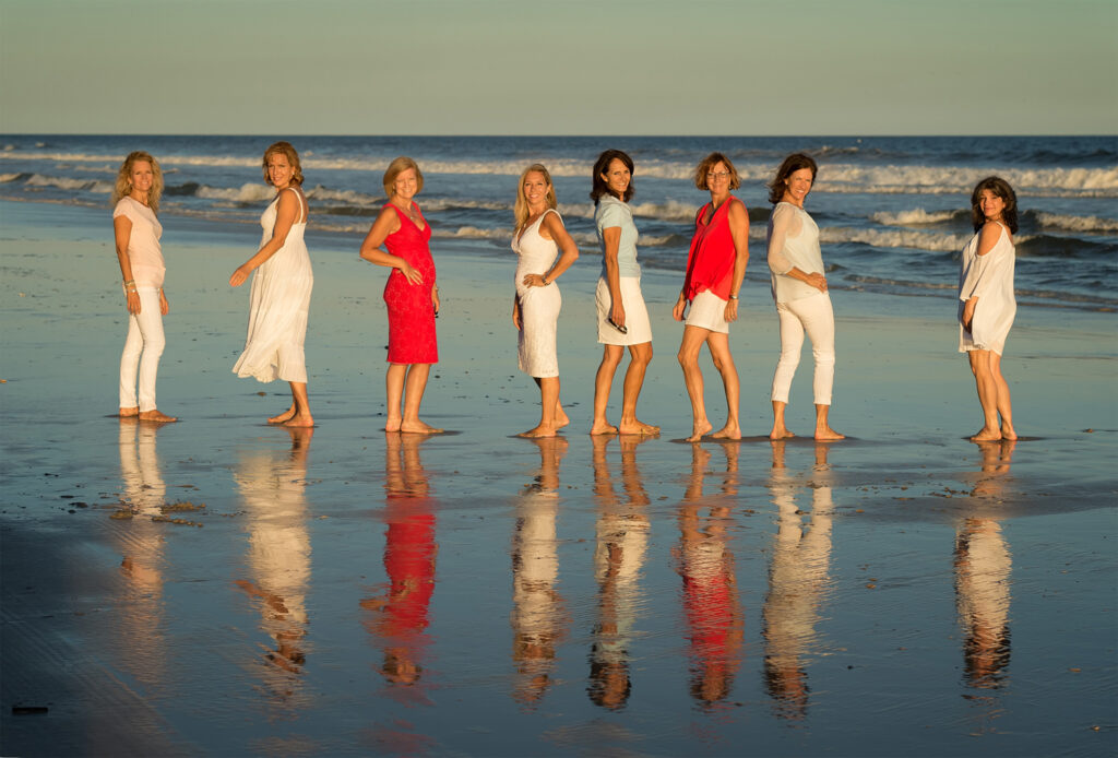 Sophisticated Portrait Photographers in Wrightville Beach, NC created this portrait of eight beautiful ladies at sunset on the beach.